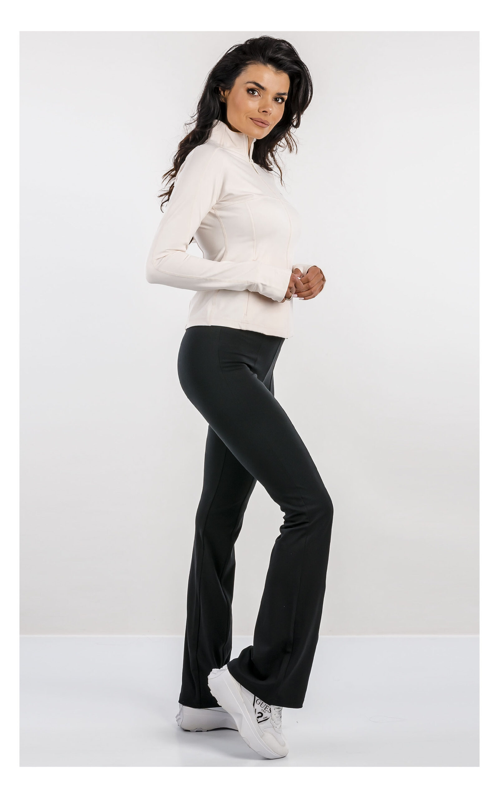 bluza o dopasowanym fasonie z tkaniny soft touch marki guess active w stylizacji z czarnymi dzwonami- widok z profilu na modelce