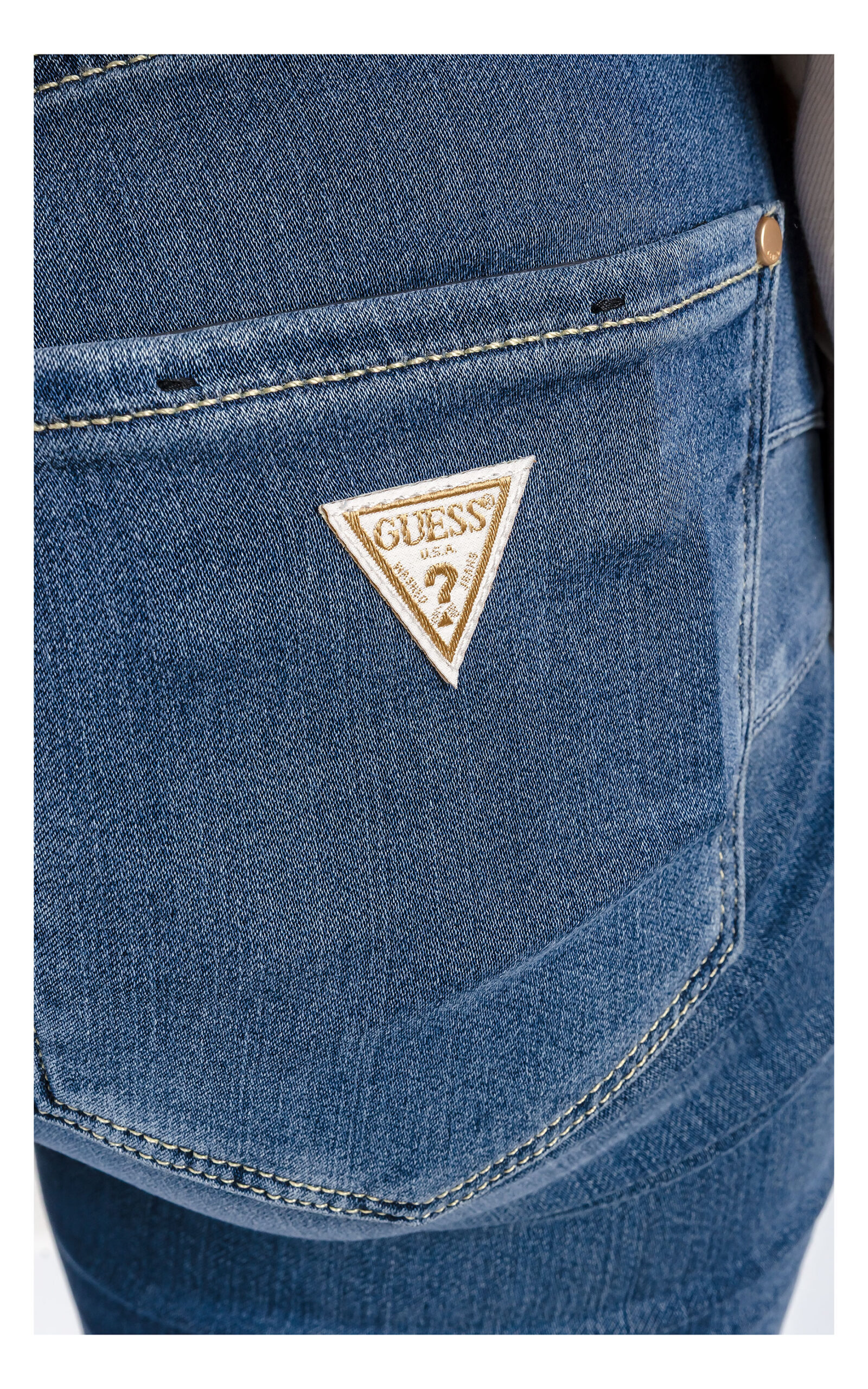 zbliżenie na logowaną naszywkę jeansów guess