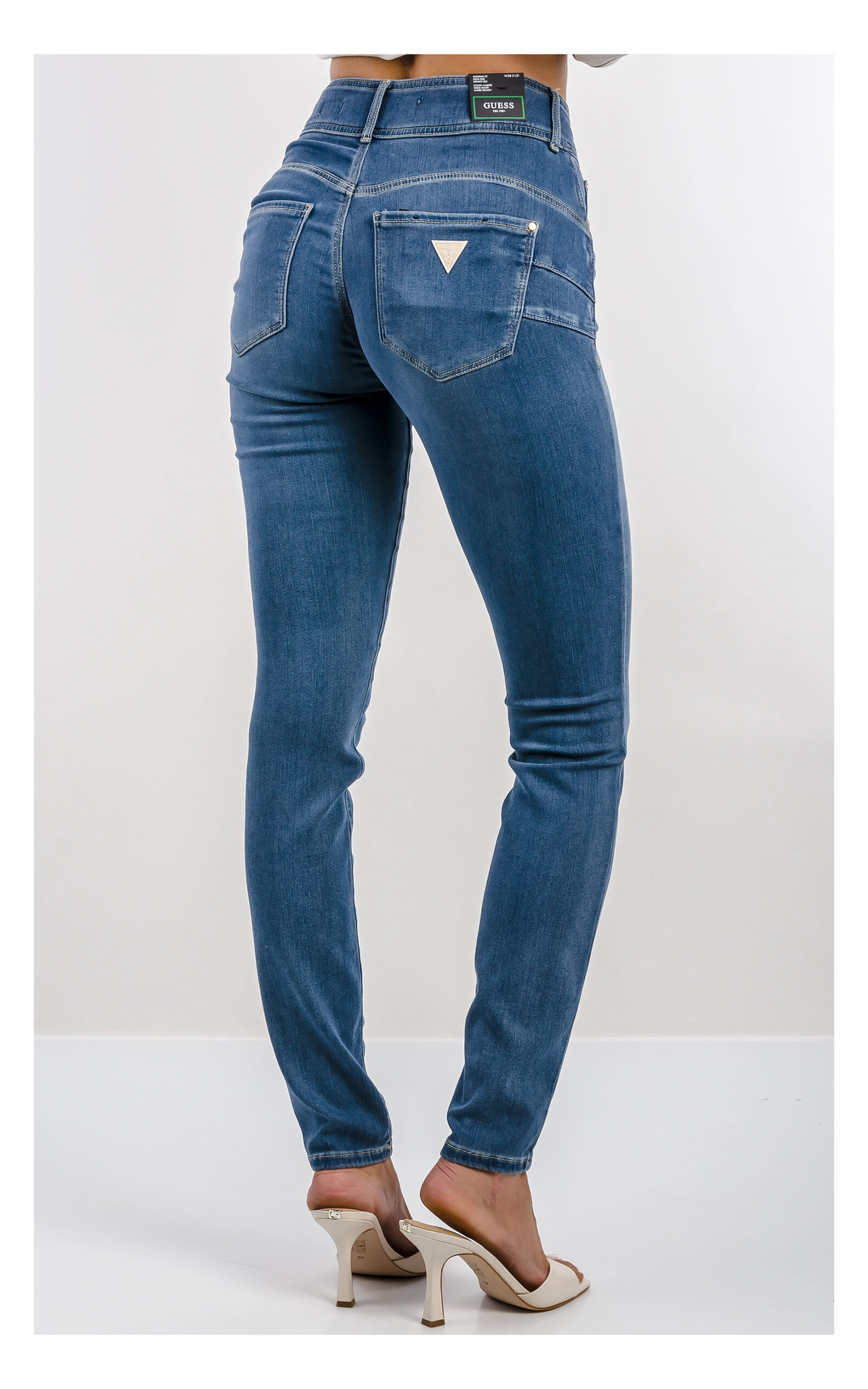 niebieskie jeansy guess skinny z wysokim stanem, model bottom up unoszący optycznie pośladki, widok na modelce od tyłu