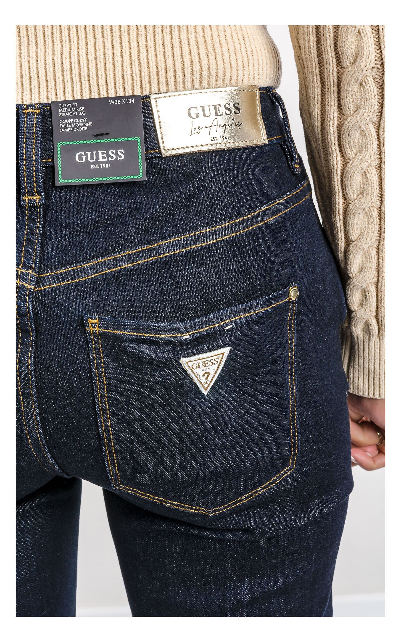 zbliżenie na kieszeń i logowaną naszywkę na jeansach guess