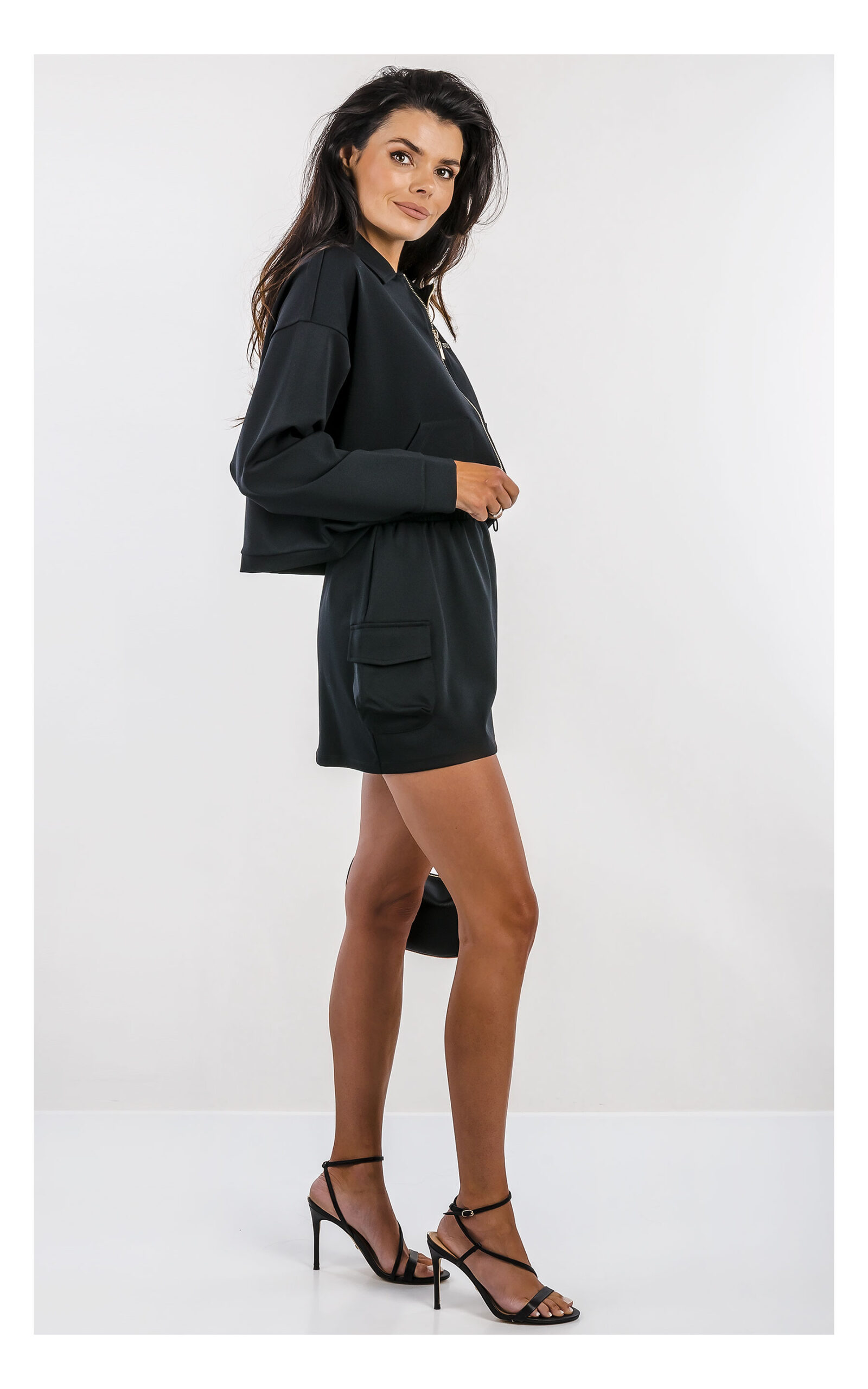 pudełkowa czarna bluza guess active w komplecie z mini spódniczką- widok na modelce z profilu