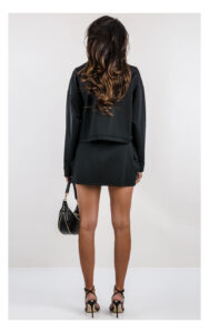 pudełkowa czarna bluza guess active w komplecie z mini spódniczką- widok na modelce od tyłu