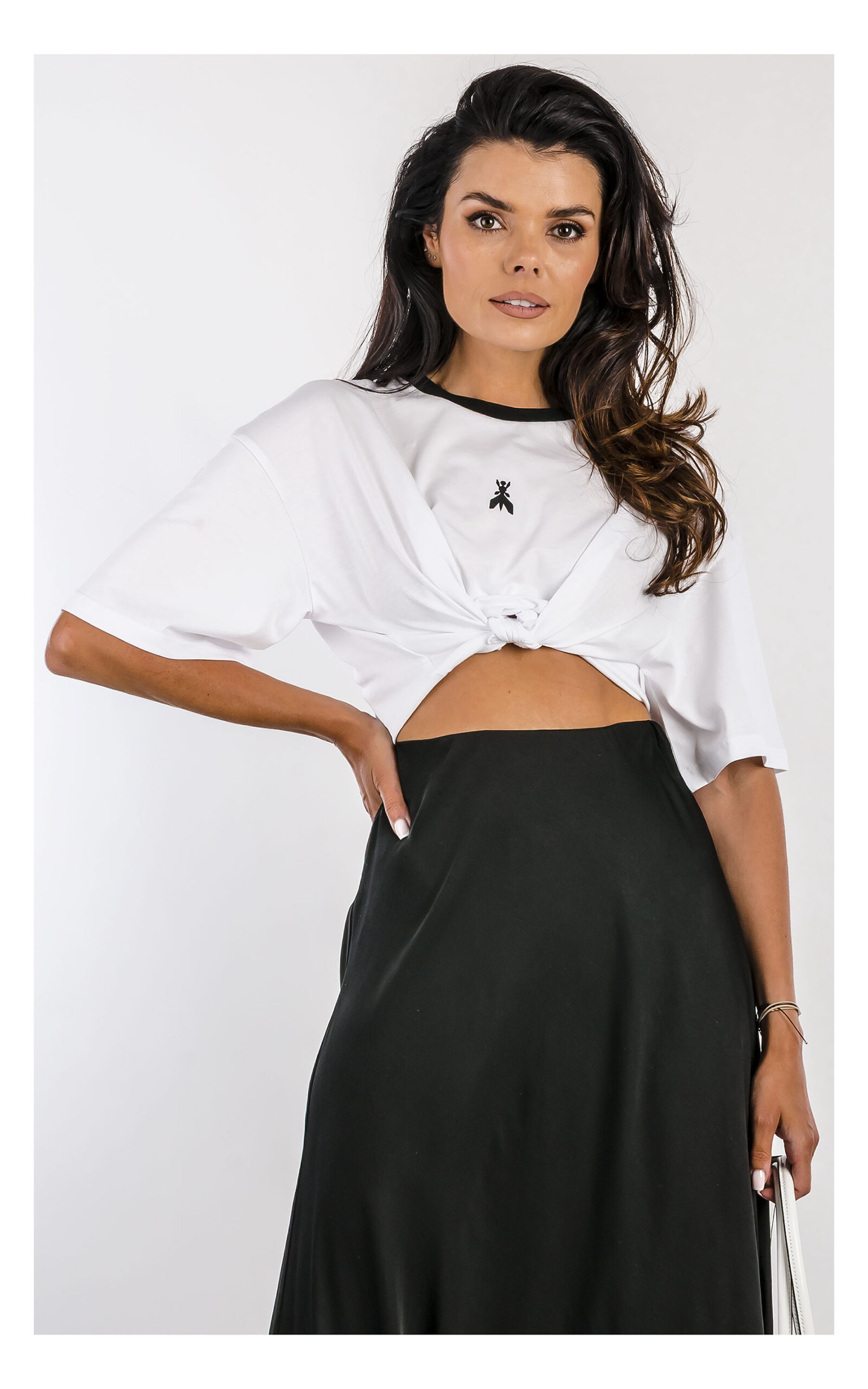 t-shirt patrizia pepe w biłaym kolorze pudełkowy, krótki fason, z logo i czarna lamówką,- widok na modelce w zbliżeniu