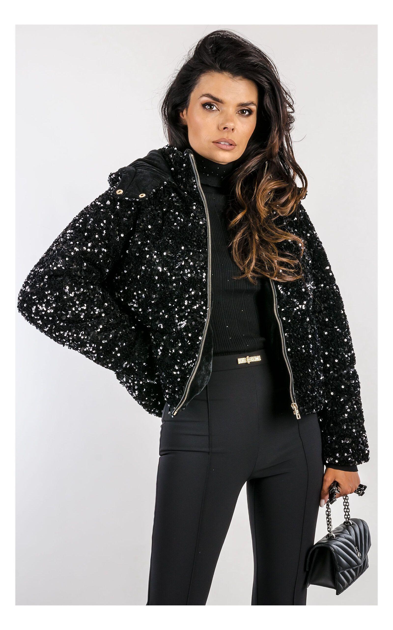 czarna kurtka cekinowa marki fracomina, fason regular fit, z kapturem - stylizacja z czarnymi eleganckimi spodniami typu flare- widok na modelce w zbliżeniu od przodu