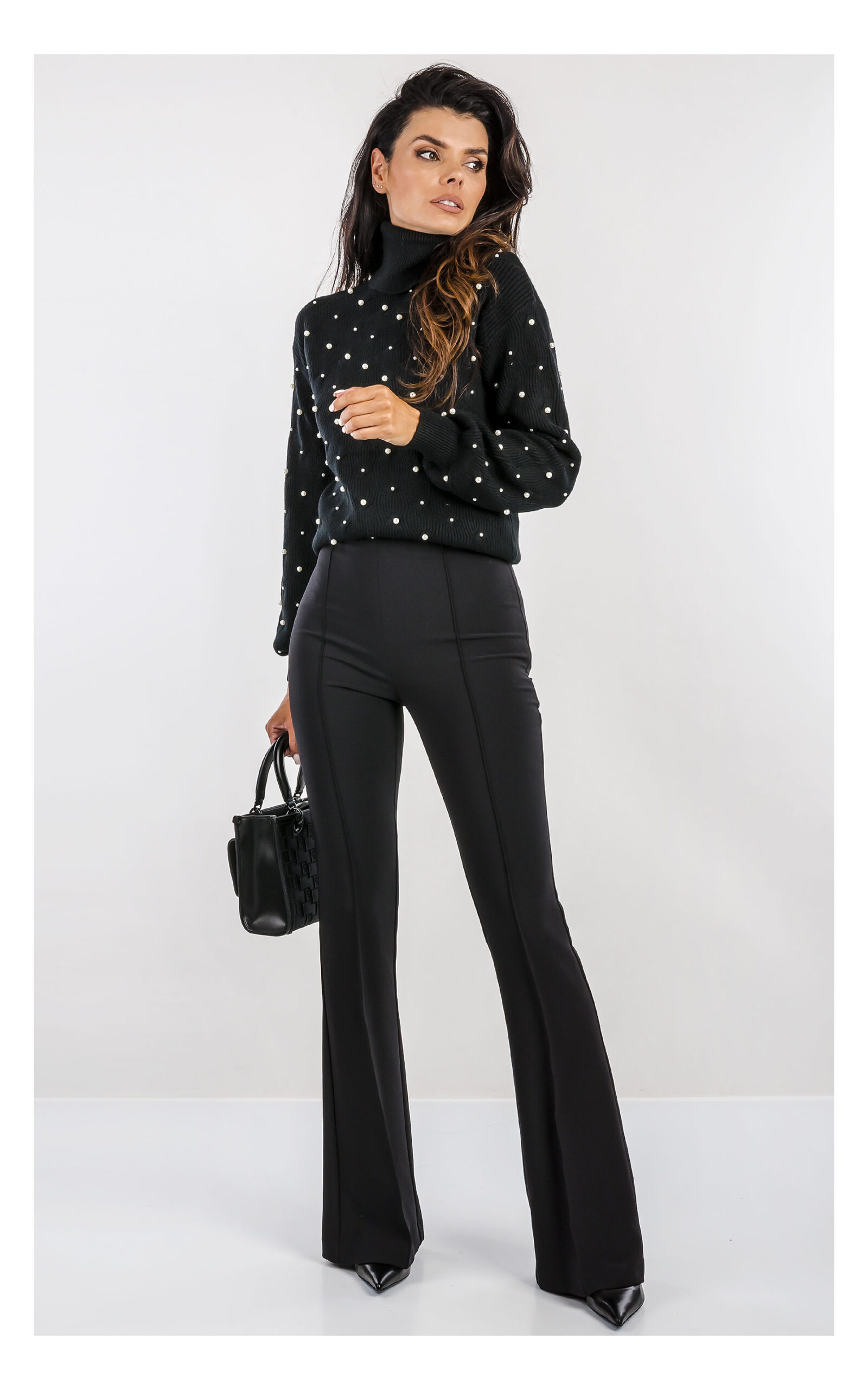 czarny sweter fracomina z miękkiej dzianiny z delikatnym splotem, zdobiony syntetycznymi perełkami, fason regular fit z golfem-stylizacja z czarnymi eleganckimi spodniami flare- widok na modelce od przodu