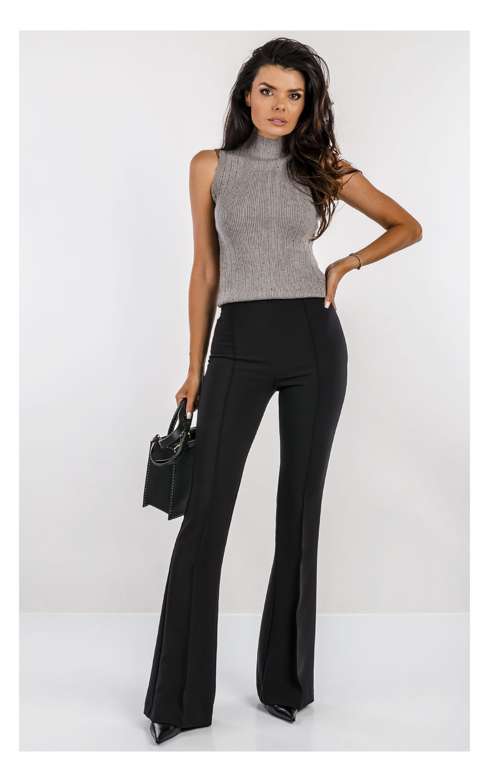szary top fracomina z dzianiny zdobiony dżetami, fason slim fit z półgolfem- stylizacja z eleganckimi czarnymi spodniami flare- widok na modelce w od przodu