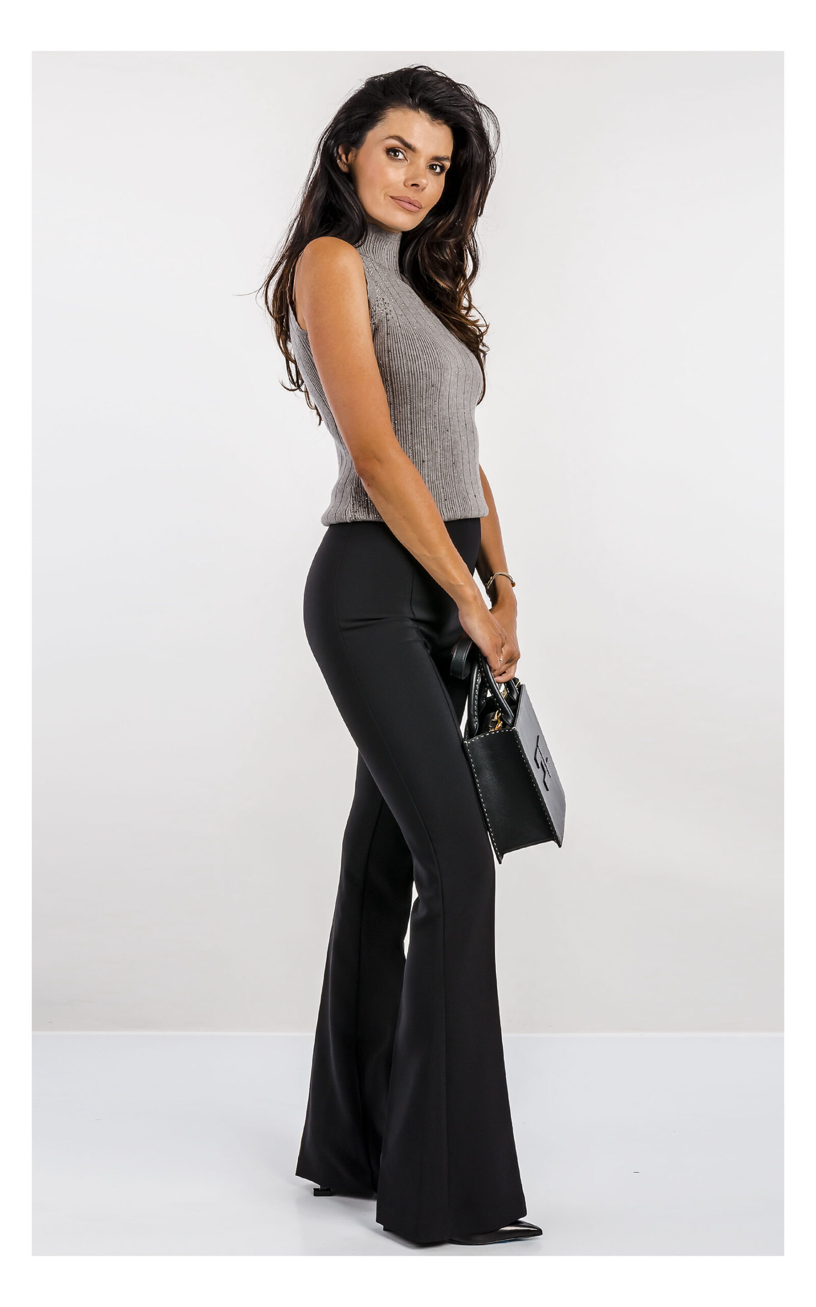 szary top fracomina z dzianiny zdobiony dżetami, fason slim fit z półgolfem- stylizacja z eleganckimi czarnymi spodniami flare- widok na modelce z profilu