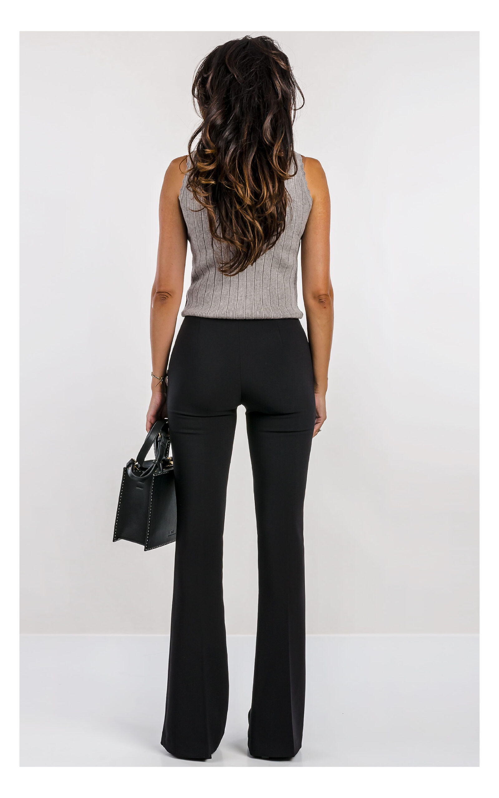 szary top fracomina z dzianiny zdobiony dżetami, fason slim fit z półgolfem- stylizacja z eleganckimi czarnymi spodniami flare- widok na modelce w od tyłu