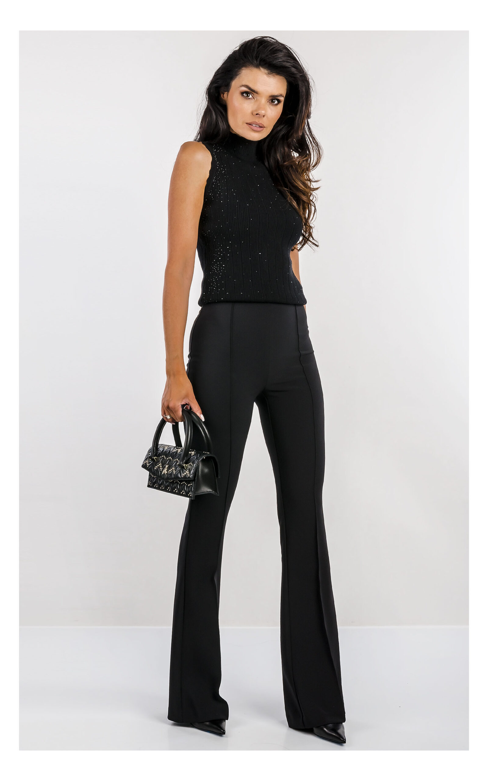 czarny top fracomina z dzianiny zdobiony dżetami, fason slim fit z półgolfem- stylizacja z eleganckimi czarnymi spodniami flare- widok na modelce w od przodu