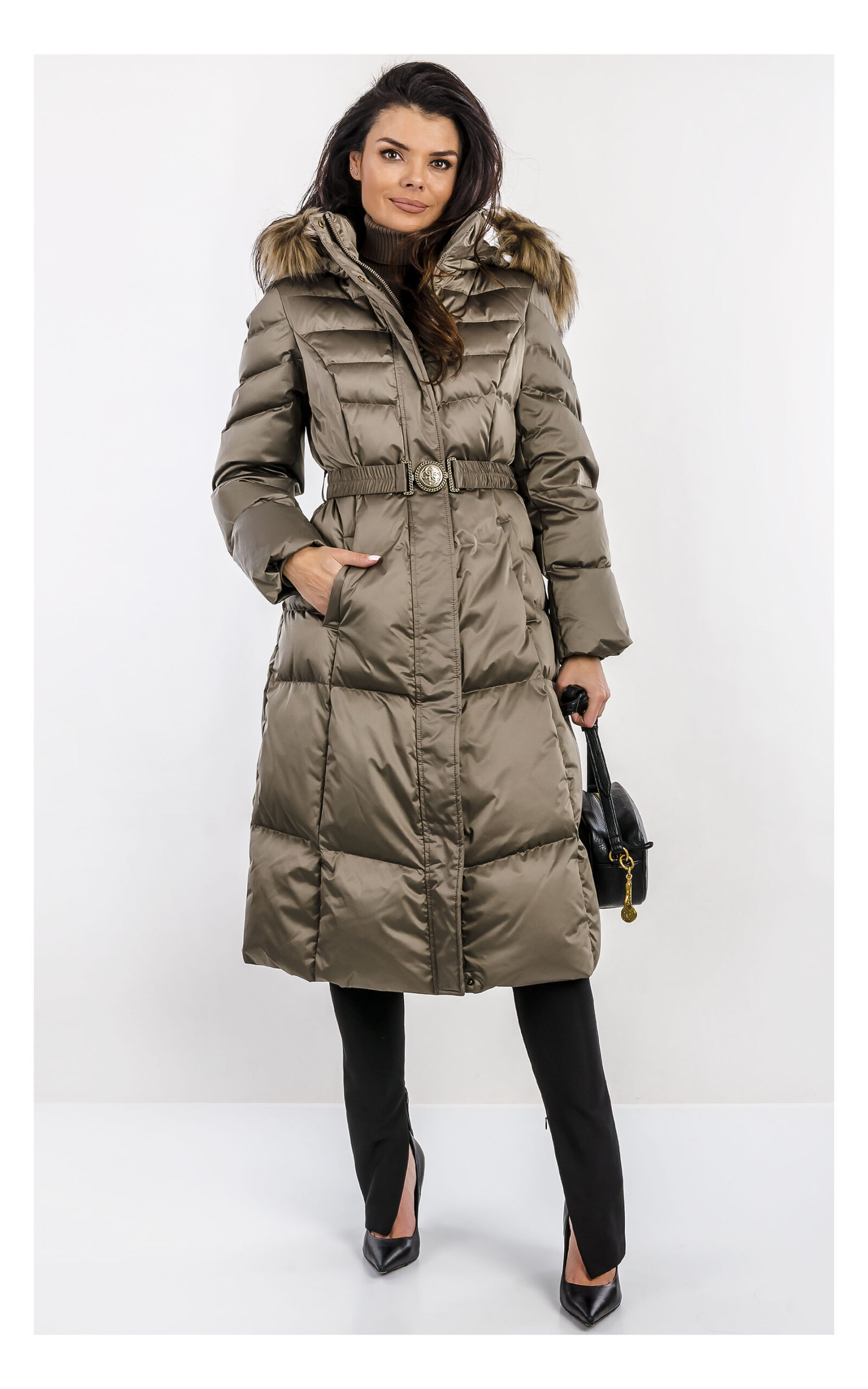 Khaki damski pikowany płaszcz Guess midi z paskiem w talii i zamkiem błyskawicznym, z kołnierzem i długimi rękawami, uszyty z wodoodpornego materiału, widok produktu na jasnym tle, na modelce od przodu