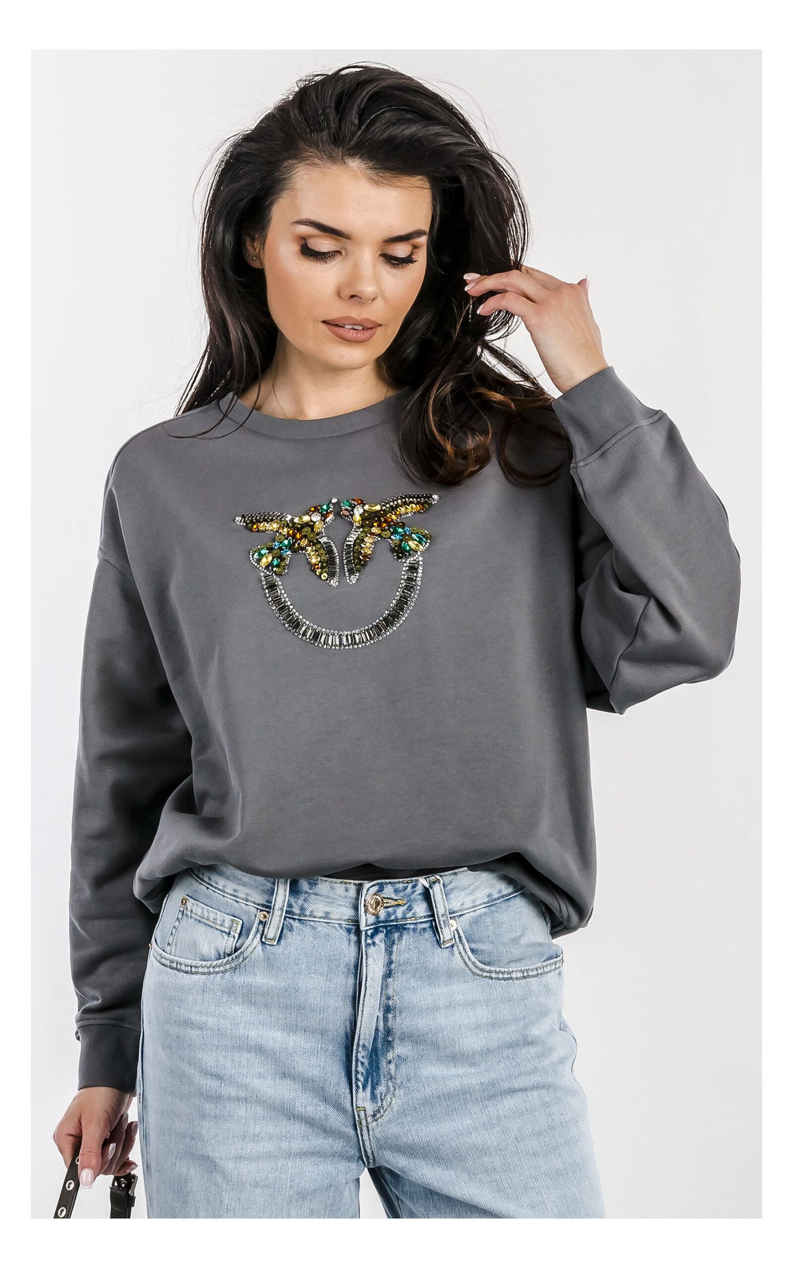 Bluza Pinko Nelly szara z kryształkowym logo – damska wkładana bluza relaxed fit z ozdobnym logo marki wyszywanym kamieniami – modna bluza premium do codziennych stylizacji- widok na modelce od przodu w przybliżeniu