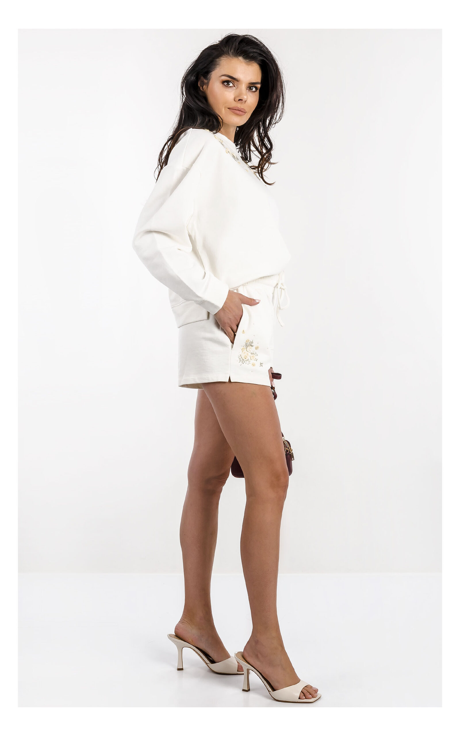 Bluza damska TWINSET oversize kremowa z aplikacją – bluza wkładana przez głowę z modnym detalem logo – stylowa bluza casual chic- widok na modelce z profilu