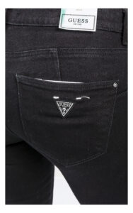 zbliżenie na logowaną naszywkę na kieszeni jeansów guess