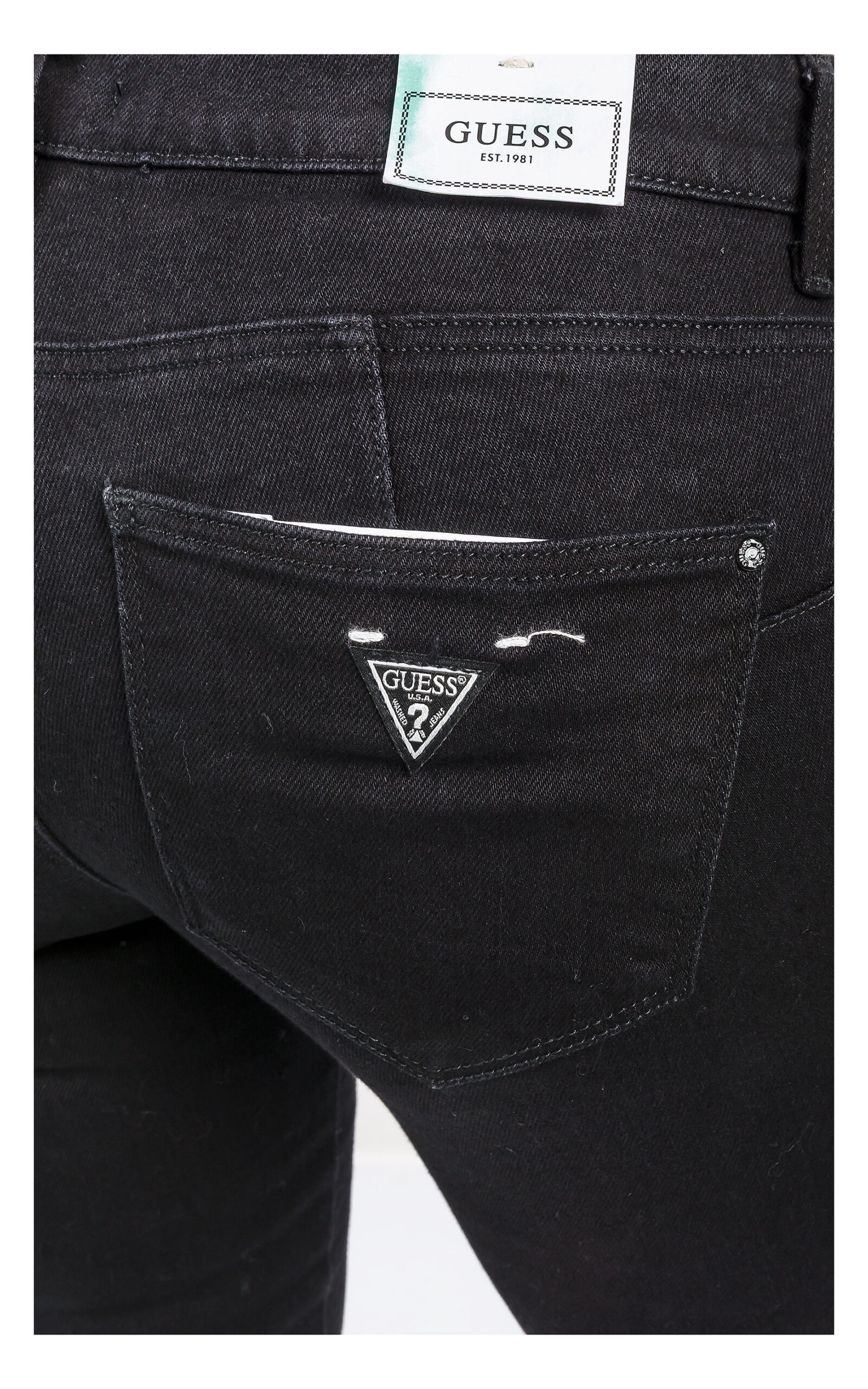 zbliżenie na logowaną naszywkę na kieszeni jeansów guess