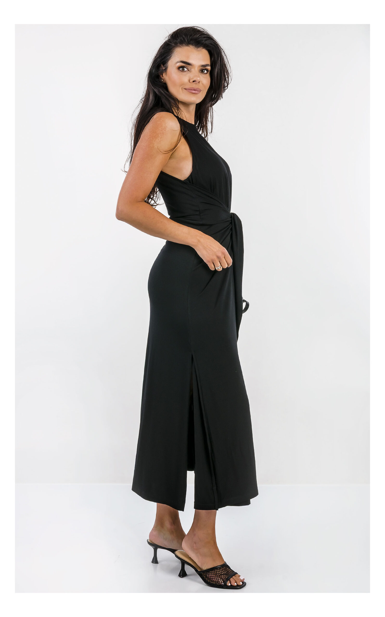 Emporio Armani długa czarna sukienka damska maxi z ozdobnym wiązaniem i dopasowanym fasonem. Widok na modelkę z profilu.