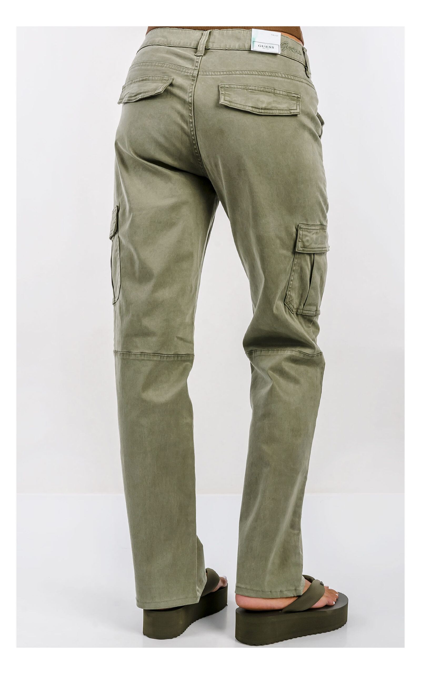 Spodnie GUESS cargo oliwkowe z wysokim stanem i praktycznymi kieszeniami, casualowy model damski o modnym fasonie. Widok na modelce od pasa w dół.